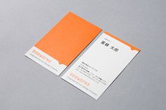 an orange and white business card sitting on top of a gray surface with chinese writing