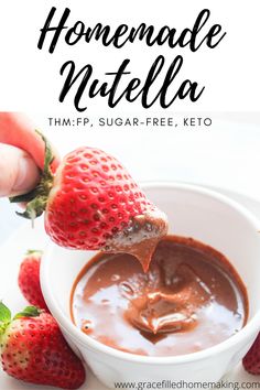 homemade nutella with chocolate and strawberries in a white bowl on a plate, being held up by a spoon