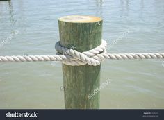 a rope tied to a wooden post in the water