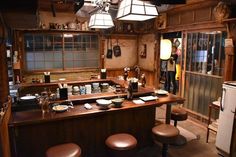 an old fashioned kitchen with lots of counter space and stools in the center area