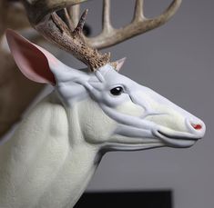 a white deer statue with antlers on it's head