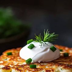 a stack of pancakes topped with whipped cream and green onions