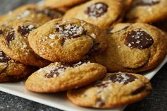 chocolate chip cookies on a white plate with sea salt sprinkled on the top