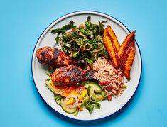 a white plate topped with meat and veggies on top of a blue table