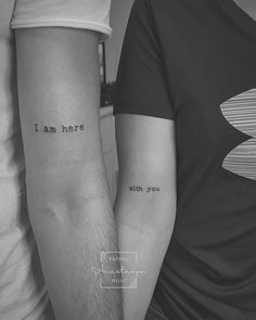 two people with matching tattoos on their arms that say i am here, with you