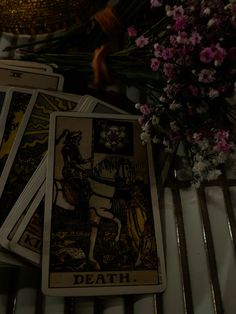 four tarot cards sitting on top of a table next to flowers