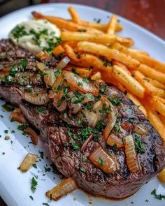 steak and fries on a white plate with parsley sprinkled on the top