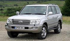 a silver suv parked on top of a gravel road