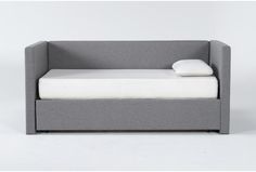 a gray couch with a white pillow on it's side and a bed in the middle