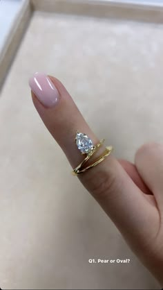 a woman's hand with a ring on it and a diamond in the middle