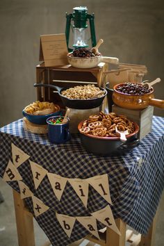 a table topped with lots of food on top of a blue and white checkered table cloth