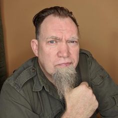 a man with a long beard sitting at a table