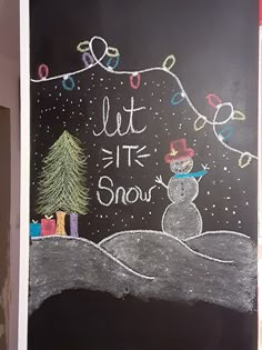 a chalk board with a drawing of a snowman and a christmas tree on it