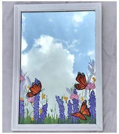 there are many butterflies flying in the sky above some purple and yellow flowers on a white sheet