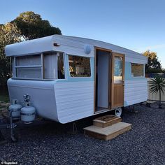 an old camper trailer is parked on gravel