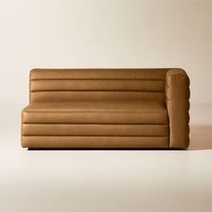 a brown leather couch sitting on top of a white floor