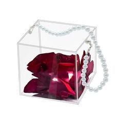 a clear box filled with red flowers and pearls on a white background for an ornament