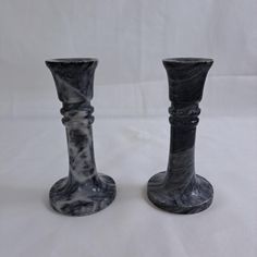 two black marble candlesticks sitting on top of each other