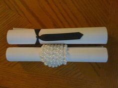 two rolls of toilet paper with beads on them sitting on a wooden floor next to each other