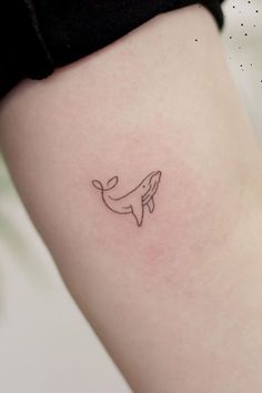 a small whale tattoo on the right thigh