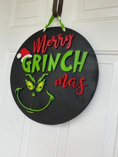 a sign that says merry grinch mas on the front of a door with an elf's face