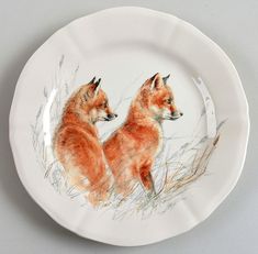 a plate with two foxes painted on it