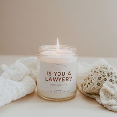 a white candle sitting on top of a table next to a pile of cloths