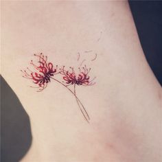 a small red flower tattoo on the side of a woman's right leg and neck