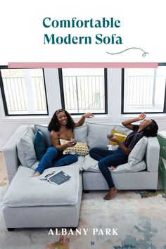 two women sitting on a couch with the caption comfortableable modern sofa by albany park