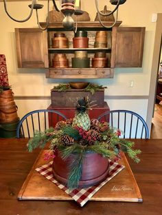 a wooden table topped with a potted plant and pine cones