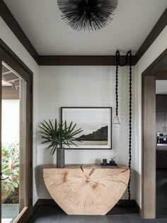 a plant is sitting on top of a wooden table in the middle of a room