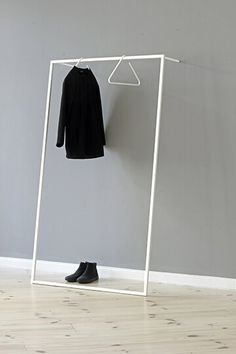 a white clothes rack with a black shirt hanging on it