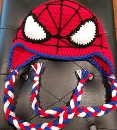 a crocheted spiderman hat with braids on it sitting on top of a table