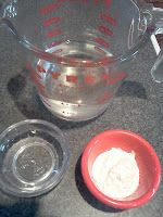 a blender with some ingredients in it on a counter top next to a red bowl