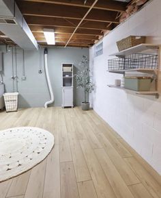 an empty room with wooden floors and shelves on either side of the wall, in front of a white brick wall