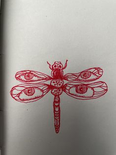 a red dragonfly drawn on white paper