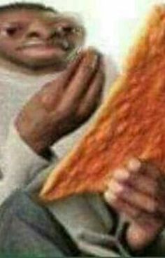 a man holding up a large piece of pizza