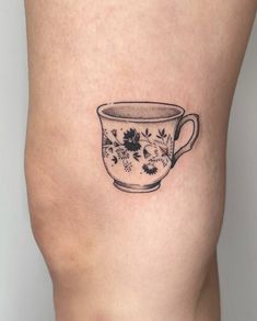 a woman's thigh with a tea cup tattoo on it