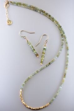 Add a touch of elegance to any outfit with the Root Green Garnet Gold Earrings. These dainty earrings feature solid natural stones with bright gold accents for a chic and refined look. Whether it's a casual day out or a special occasion, these earrings are the perfect accessory. Gold Gemstone Bead Drop Earrings, Gold Drop Earrings With Gemstone Beads, Elegant Green Earrings With Natural Stones, Gold Dangle Earrings With Gemstone Beads, Dainty Diy Jewelry, Everyday Green Earrings With Natural Stones, Elegant Handmade Green Linear Earrings, Gold Teardrop Earrings With Gemstone Beads, Elegant Gold Linear Earrings With Natural Stones