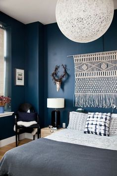 a bed room with a neatly made bed and blue walls