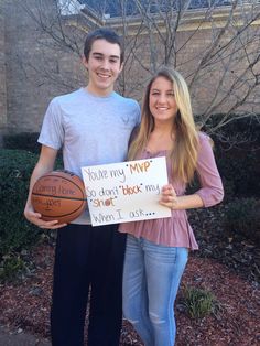 a young man and woman holding a sign that says you're my mpp so don't shoot my smart basketball