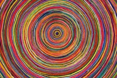 an abstract painting with multicolored lines in the middle and one circle at the center