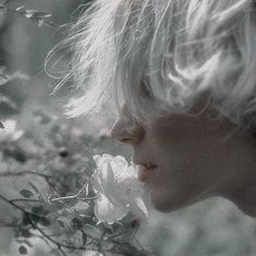 a black and white photo of a woman with flowers in her hair looking into the distance