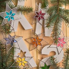 the numbers are made out of stained glass and decorated with pine branches on a wooden surface