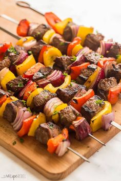 skewered meat and vegetables on a wooden cutting board