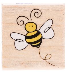 a wooden stamp with a drawing of a bee on it's chest and wings