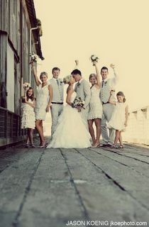 a group of people standing next to each other on top of a wooden floor in front of a building