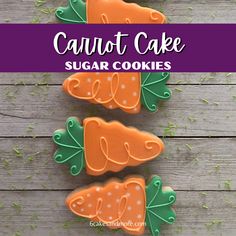 three carrot shaped sugar cookies sitting on top of a wooden table