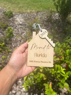 a hand holding a key to a house shaped keychain that says married to florida