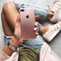 a woman sitting on the floor holding an iphone